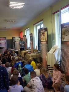 Uczniowie na wystawie o Biblii wśród banerów i eksponatów.