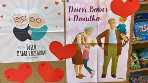 Na tablicy korkowej przyczepione dwa plakaty z okazji Dnia Babci i Dziadka oraz serca.