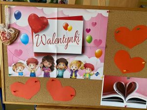 Tablica korkowa z przypiętymi plakatami walentynkowymi i sercami.