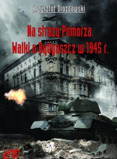 Na okładce książki: czołg w otoczeniu ruin miasta, w tle przelatuje samolot. Na górze nazwa autora, poniżej tytuł i logotyp wydawnictwa.