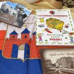 Wokół flagi z herbem Bydgoszczy leżą na stole książki o tym mieście i województwie kujawsko-pomorskim.