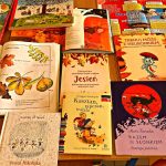 Na stole kilkanaście książek dla dzieci związanych tematycznie z jesienią.