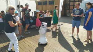 Kilka osób przygląda się robotowi humanoidalnemu.