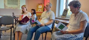 Czworo dorosłych z tekstami w dłoniach.