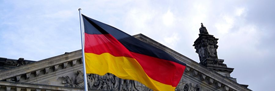 Flaga niemiecka powiewająca nad zabytkowym budynkiem.