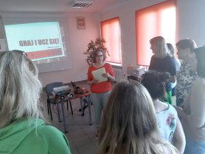 Na tle ekranu z tytułem warsztatów stoją uczestniczki spotkania.