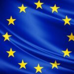 Flaga Unii Europejskiej - dwanaście żółtych gwiazd na niebieskim tle.