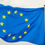Flaga Unii Europejskiej - dwanaście żółtych gwiazd na niebieskim tle.