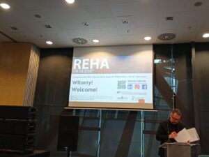 Duży ekran wyświetlający informację: Witamy! REHA for the Blind.