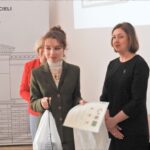 Dziewczyna z dyplomem i torebkami prezentowymi.