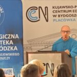 Prelegent na tle banerów PBW w Bydgoszczy i KPCEN.