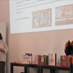 Kobiety przed dużym ekranem z prezentacją zdjęć.