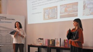 Kobiety przed dużym ekranem z prezentacją zdjęć.