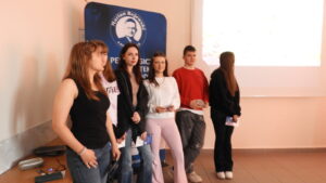 Młodzież przy banerze biblioteki.