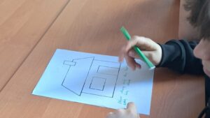 Uczeń z flamastrem w dłoni nad karta pracy.