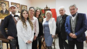 Grupa osób pozuje przy ekspozycji.