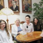Grupa osób w scenerii w stylu secesyjnym.
