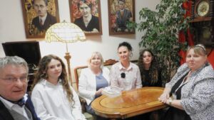 Grupa osób w scenerii w stylu secesyjnym.