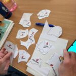 Zbliżenie na dłonie, które układają puzzle z mapą Niemiec.