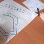 Na blacie dwie kartki, jedna z wymalowaną planszą gry, druga z wypisanymi zasadami.
