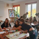 Młodzież przy stolikach, tworzy własne wersje gier planszowych.