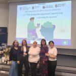 4 kobiety pozują do zdjęcia, w tle slajd z prezentacji.