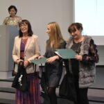 Cztery kobiety. Jedna w tle, 3 pozostałe nagrodzone dyplomami.