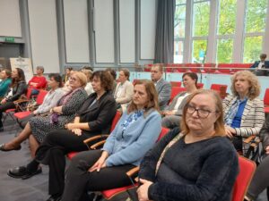 Grupa osób siedząca na krzesłach.