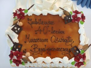 Prostokątny tort, z białym wykończeniem i brązowym lukrem, napis: Jubileusz 40-lecia Muzeum Oświaty w Bydgoszczy.