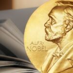 Medal noblowski na tle otwartej książki.