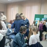 Sala pełna ludzi, dzieci, młodzieży i dorosłych w eleganckich strojach.