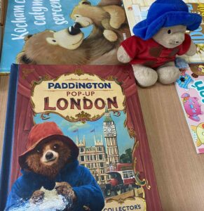 Książeczka o Misiu Paddington na stole obok pluszaka.