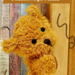 Miś spoglądający zza regału z książkami.