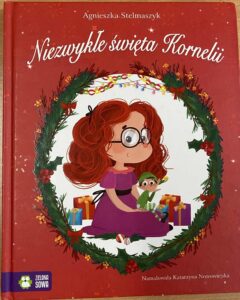Dziewczynka w okularach z elfem świątecznym w dłoni - grafika obwiedziona zieloną girlandą.