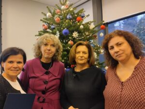 4 kobiety: brunetka, blondynka, i dwie szatynki, pozują do zdjęcia na tle choinki.