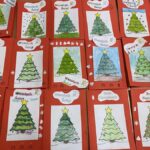 Kolaż czerwonych kartek świątecznych z choinkami.