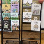 Książki dla dzieci wystawione na dwóch stojakach.