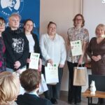 Sala audytoryjna pełna słuchaczy, do zdjęcia pozuje 6 kobiet.