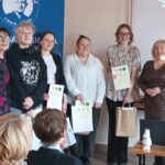 Sala audytoryjna pełna słuchaczy, do zdjęcia pozuje 6 kobiet.