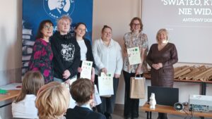 Sala audytoryjna pełna słuchaczy, do zdjęcia pozuje 6 kobiet.