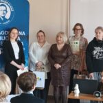 Sala audytoryjna pełna słuchaczy, do zdjęcia pozuje 6 kobiet.