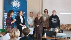 Sala audytoryjna pełna słuchaczy, do zdjęcia pozuje 6 kobiet.