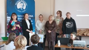 Sala audytoryjna pełna słuchaczy, do zdjęcia pozuje 6 kobiet.
