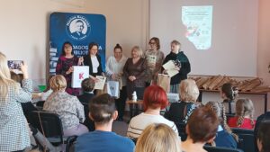 Sala audytoryjna pełna słuchaczy, do zdjęcia pozuje 6 kobiet.