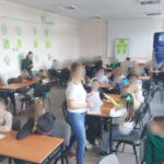 Sala zajęciowa. Dzieci siedzą w kilku grupach przy stolikach.