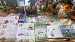 Kilka książeczek dla dzieci w otoczeniu ozdób wielkanocnych.