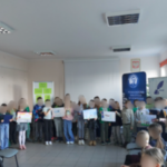 Grupa dzieci pozuje z pracami plastycznymi w rękach.