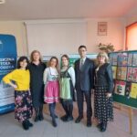 Organizatorzy konkursu pozują przy wystawie prac konkursowych i banerach PBW i PSNJN