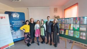 Organizatorzy konkursu pozują przy wystawie prac konkursowych i banerach PBW i PSNJN