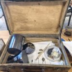 Otwarta drewniana walizka wypełniona próbkami krzemowymi i papierami.